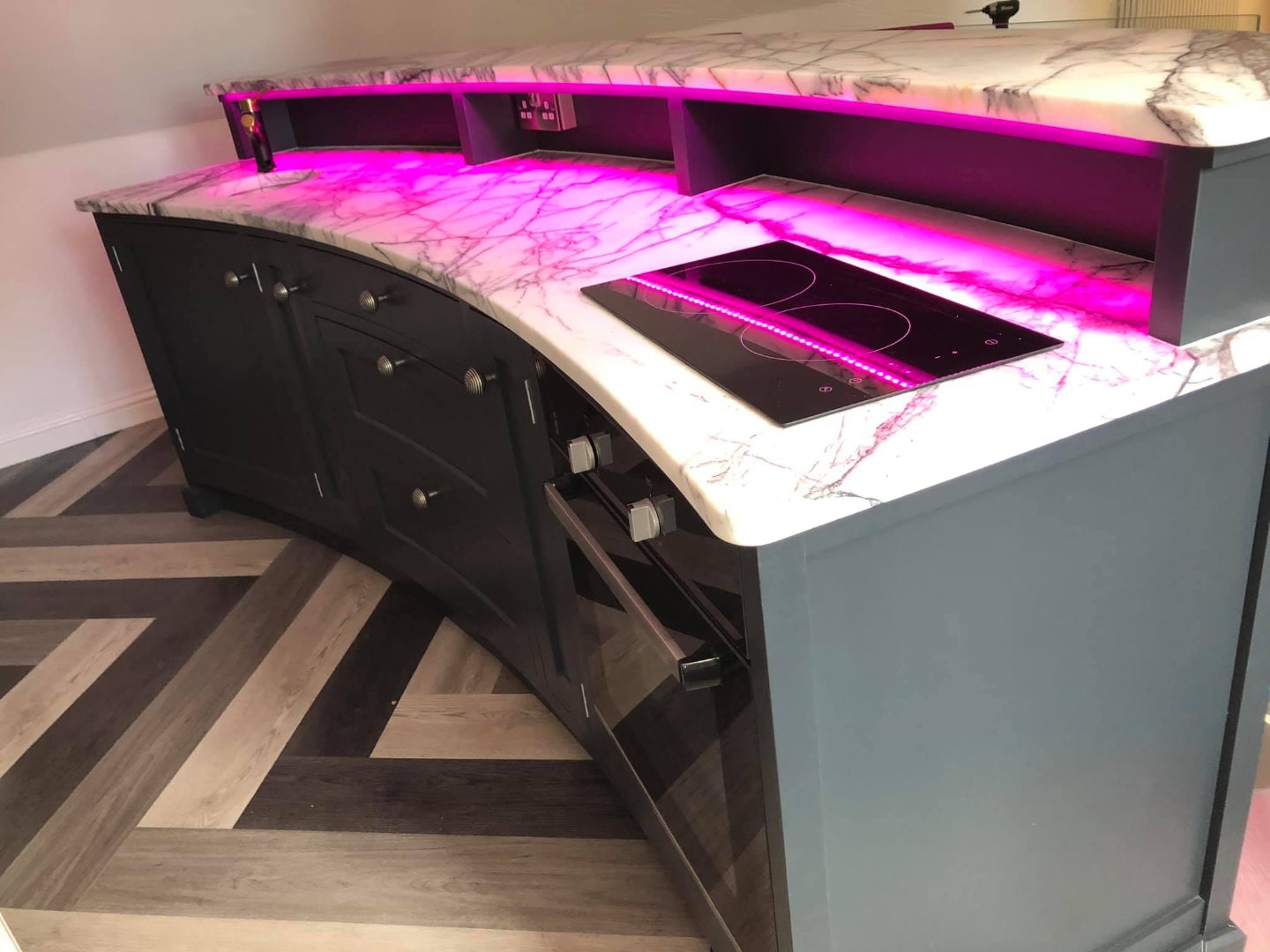 A marble worktop with integrated hob on a bespoke drinks bar.