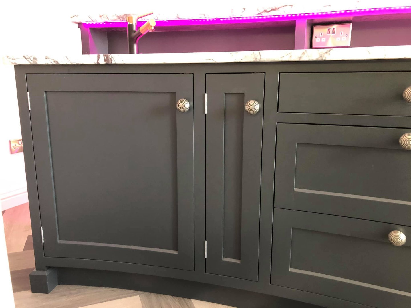 Storage cabinets fitted beneath a bespoke drinks bar.