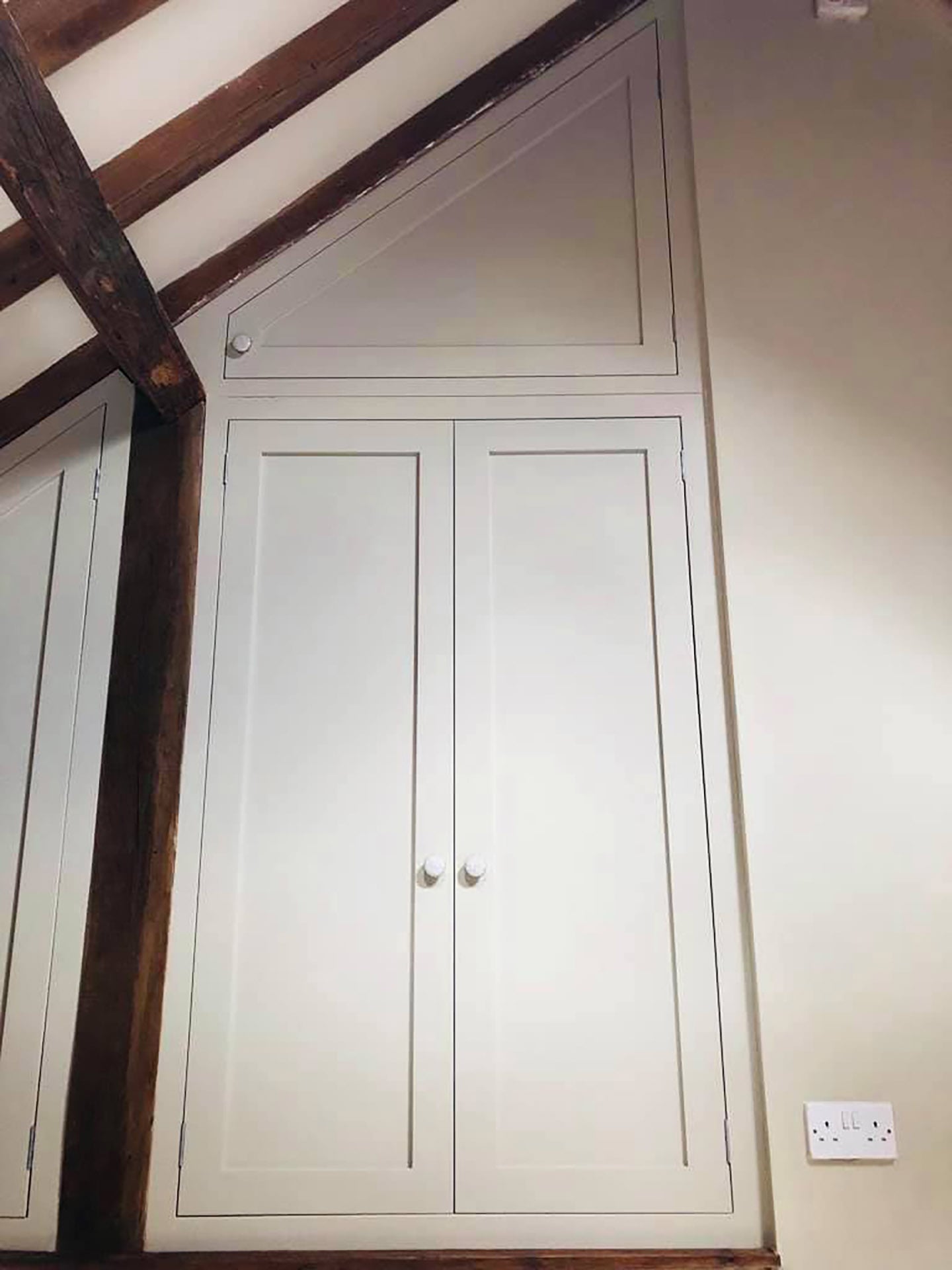 Bespoke wardrobe in attic bedroom with wooden beams