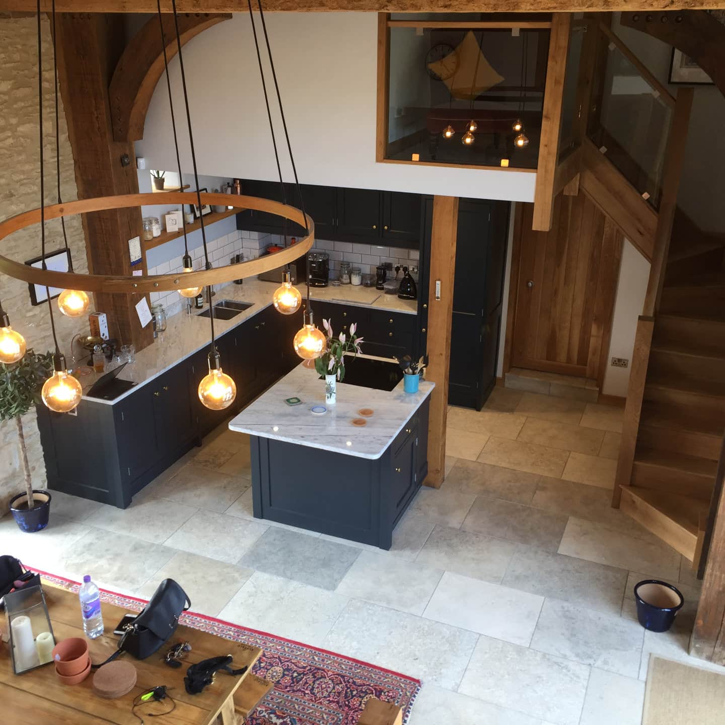 A view through some lights of a bespoke kitchen fitted inside a barn conversion.