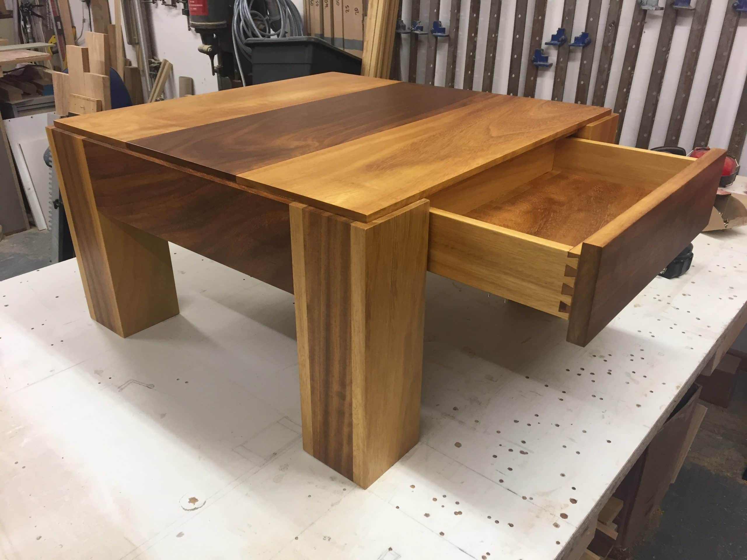 A custom made coffee table with an open drawer underneath