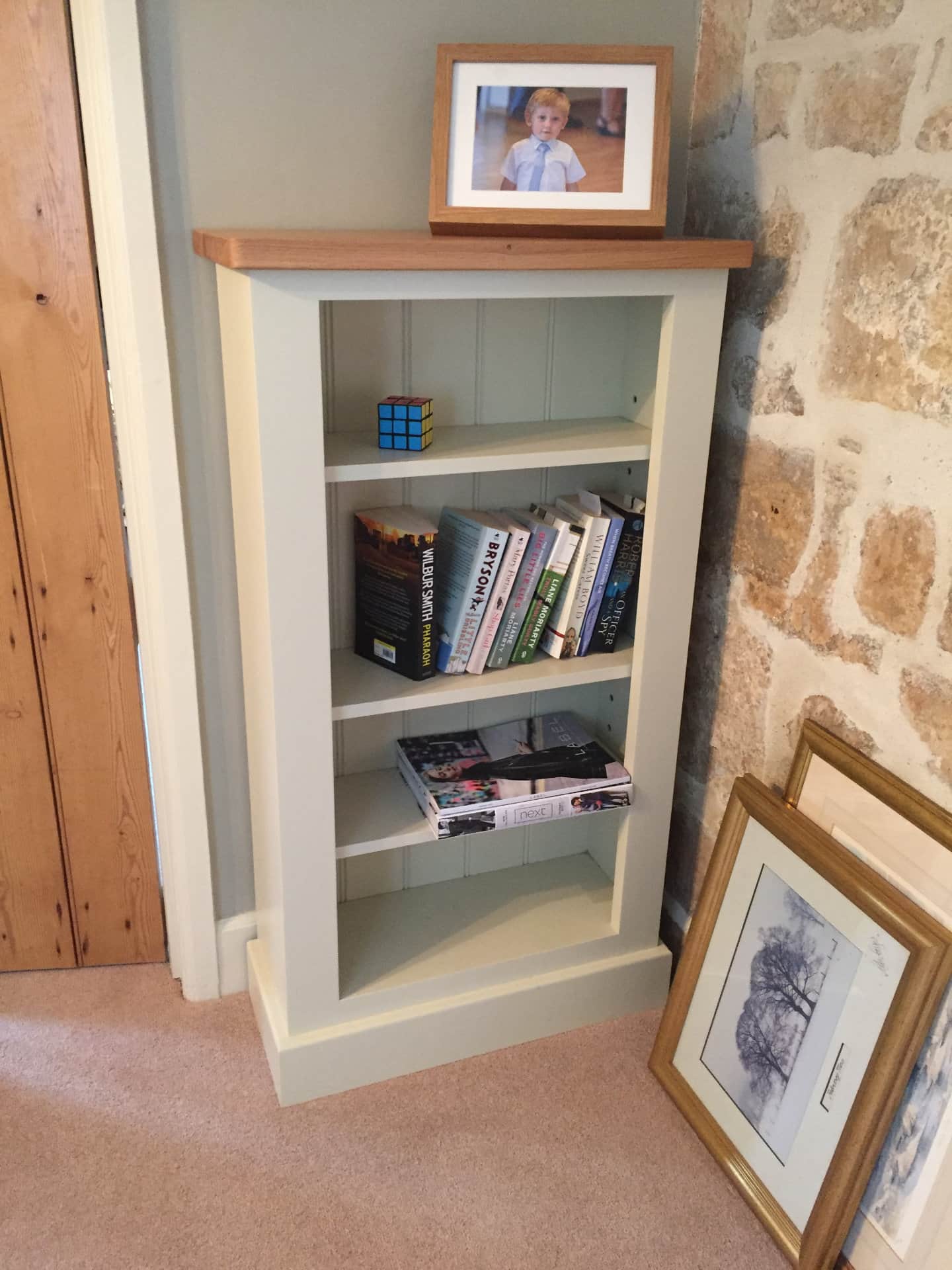 A bespoke bookcase with an assortment of books on it