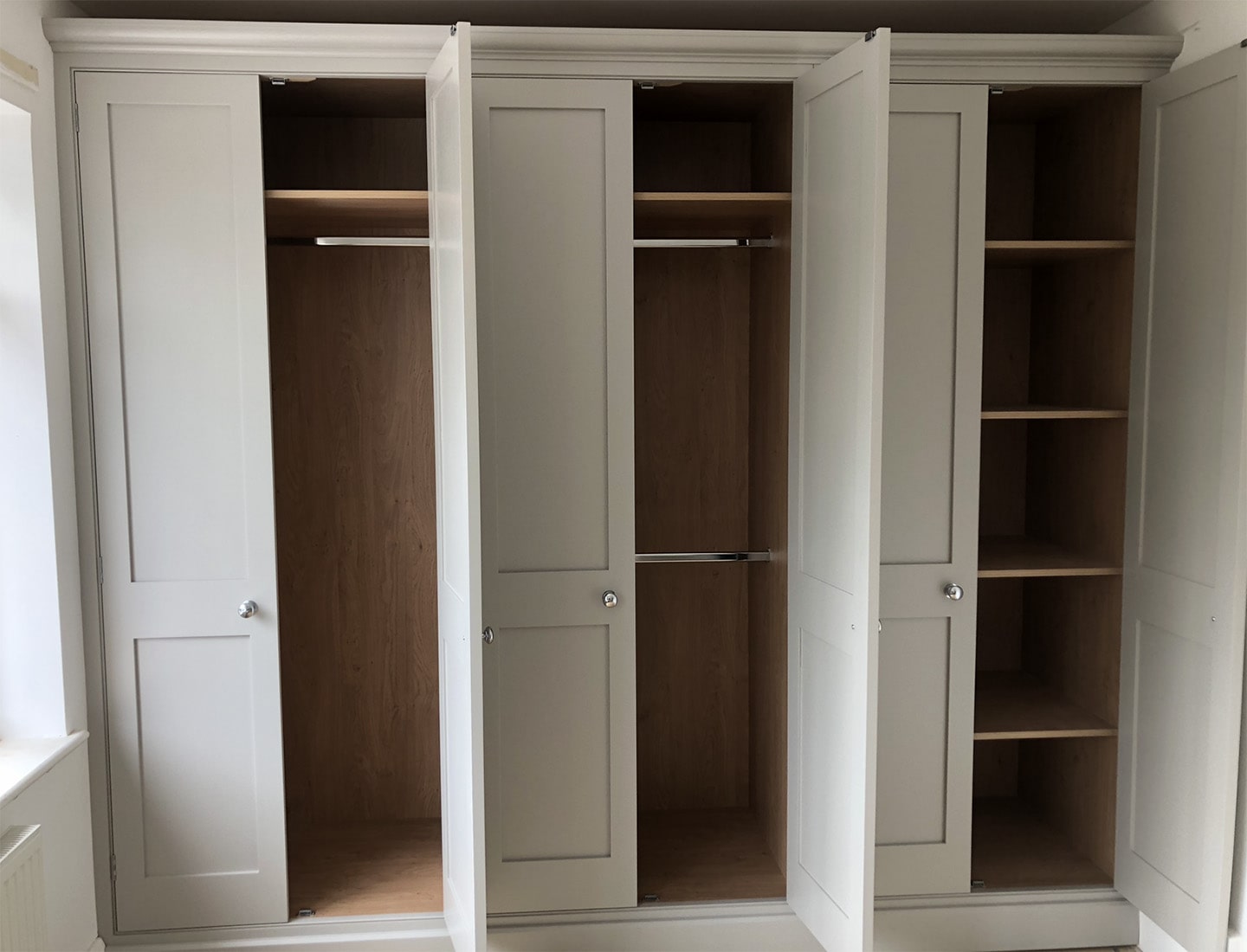 A collection of bespoke wardrobes with their doors open.