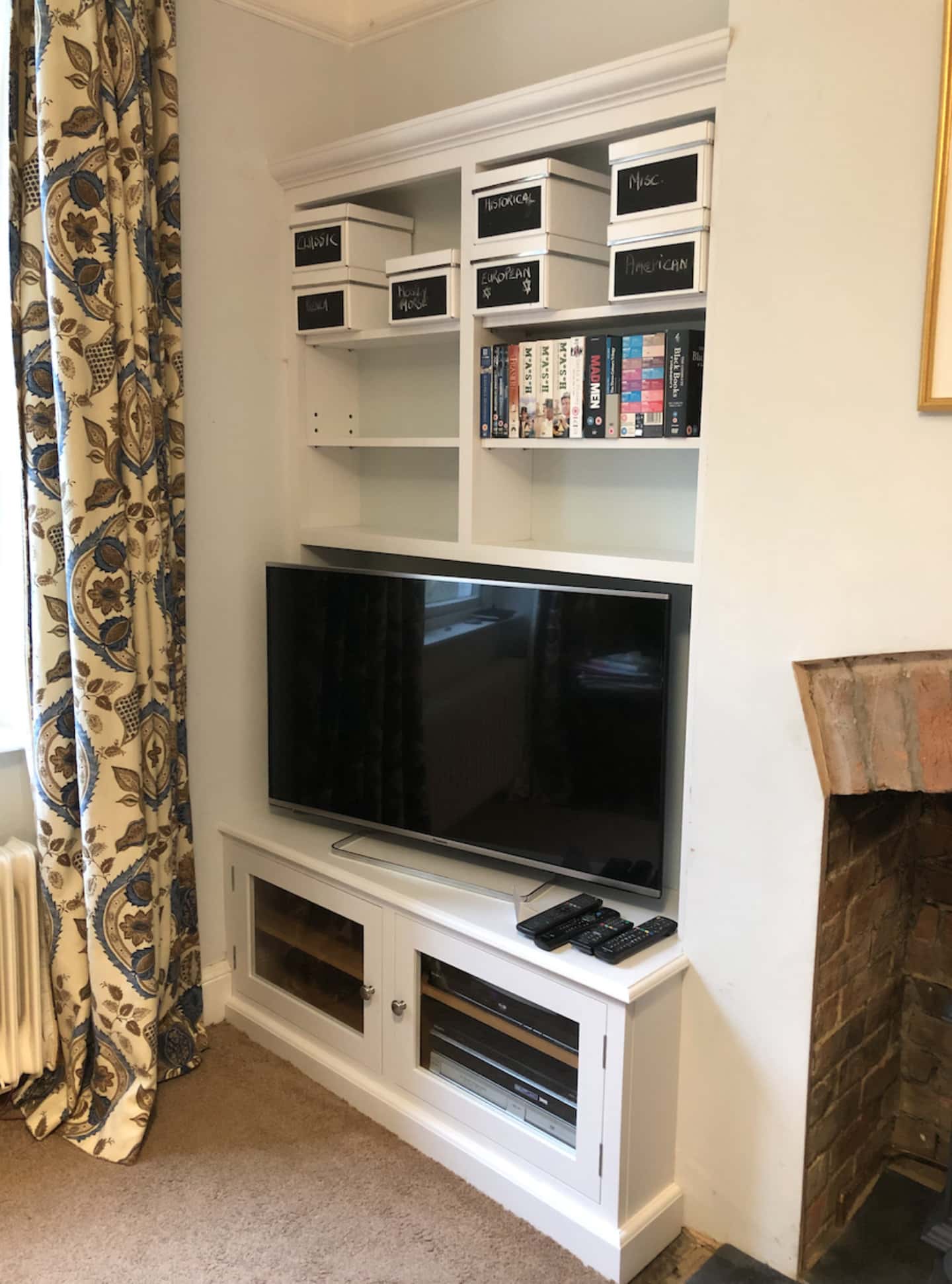 A bespoke bookcase with a flat screen TV on it.