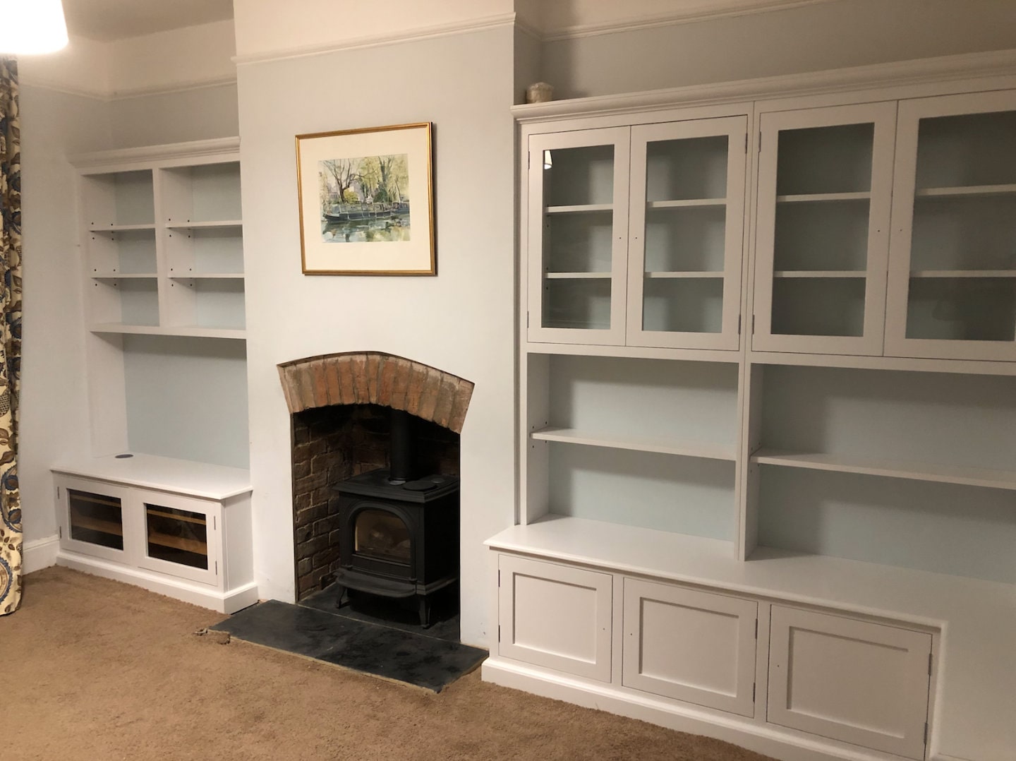 Two bespoke bookcases with a fireplace between them.