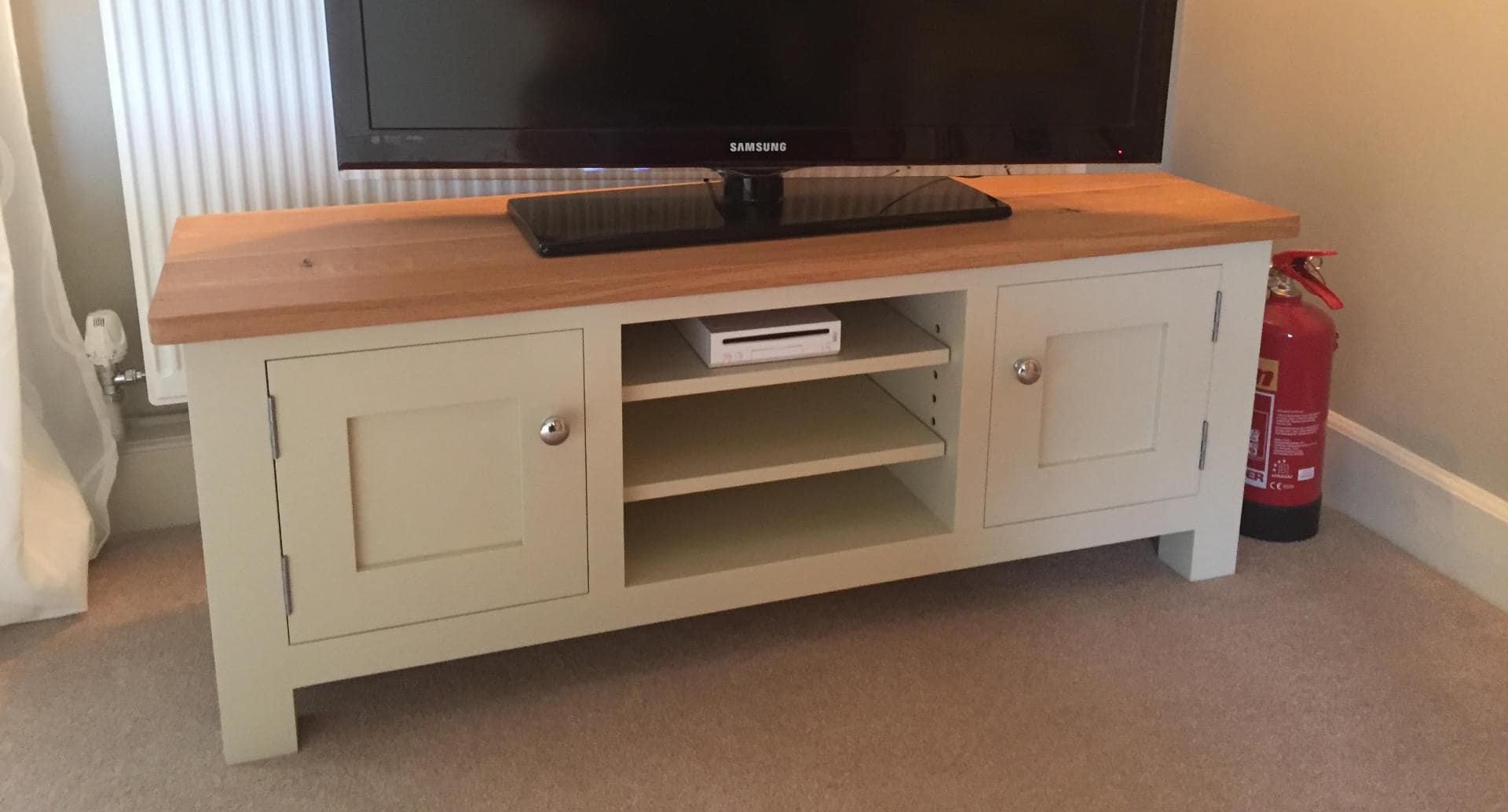 A TV place upon a bespoke, wooden, TV stand