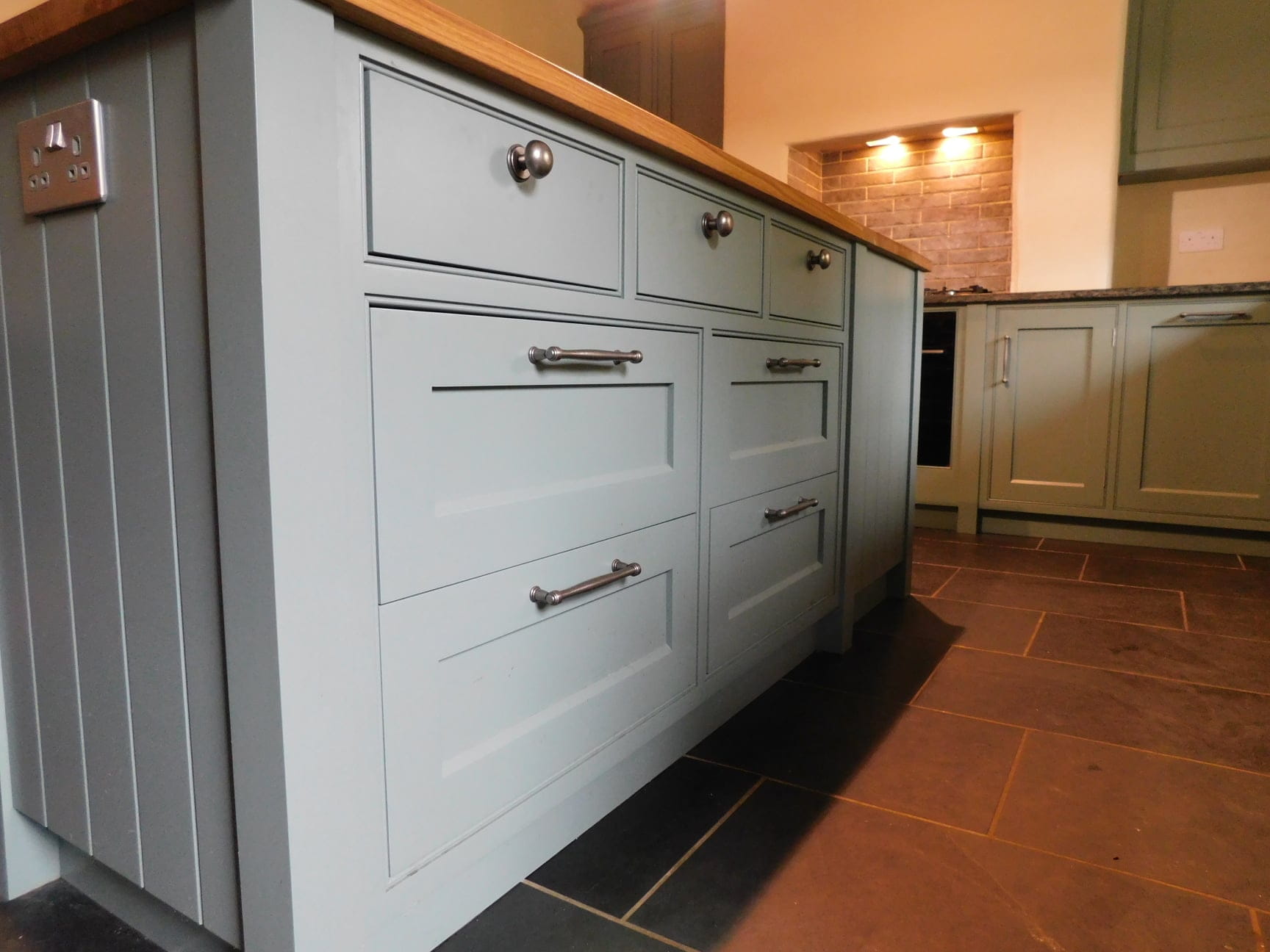 An island counter with cupboards and drawers.