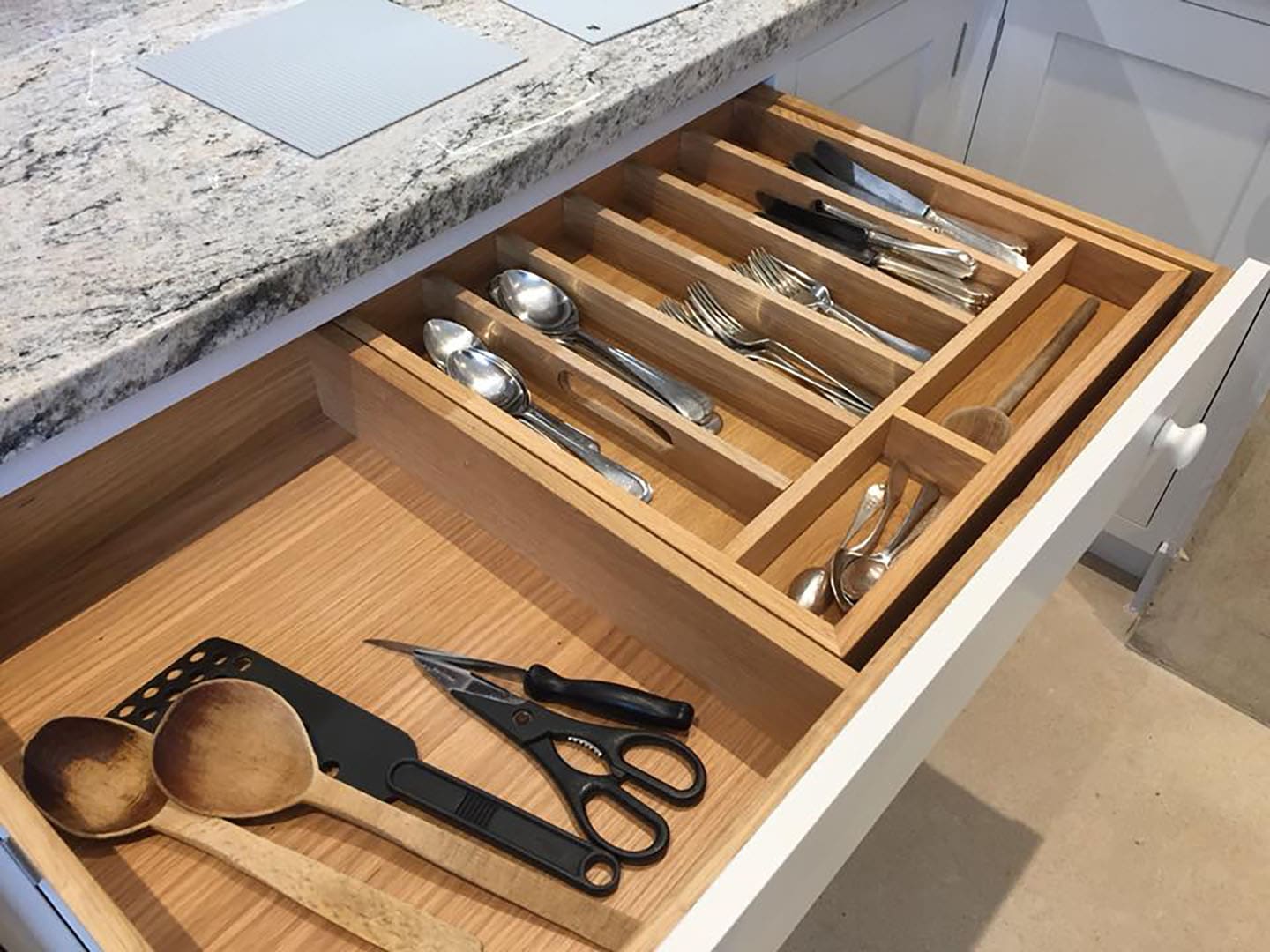 The cutlery draw showing the utensils inside.
